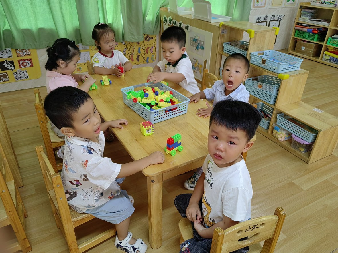 孩子们坐在桌边看镜头