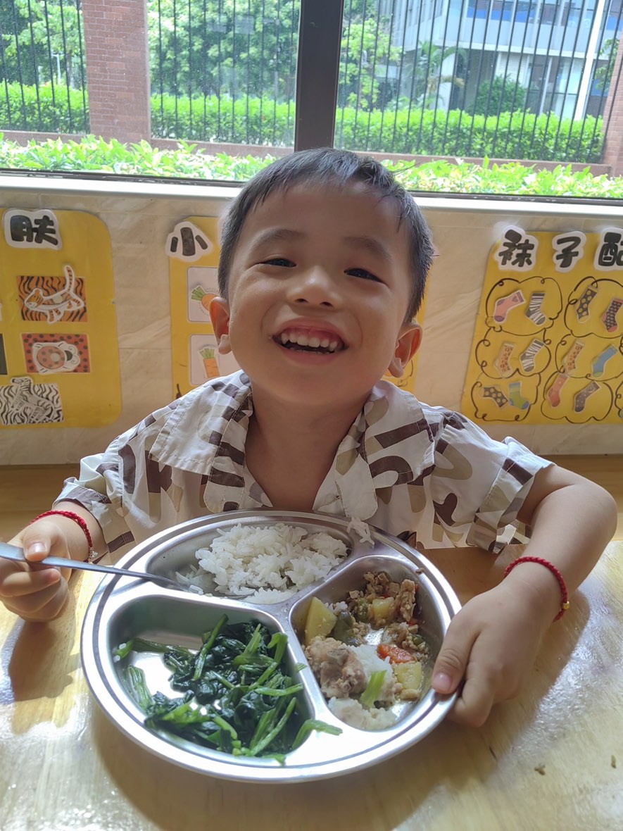 孩子端着餐盘笑